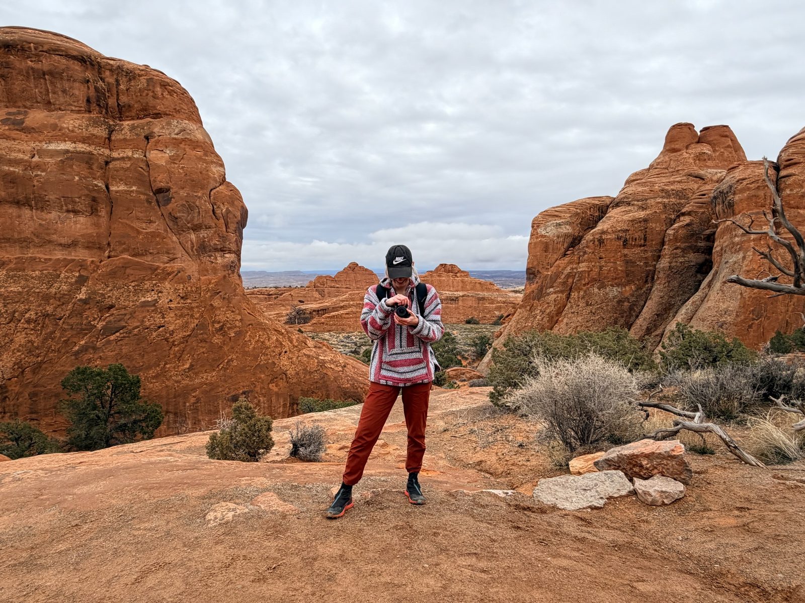 Bri checking her camera in Arches National Park